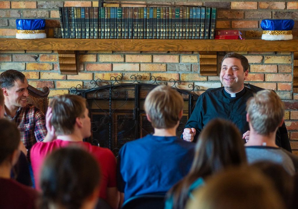 Monsignor James Shea, president of University of Mary, speaking with students. | Credit: Mike McCleary/University of Mary