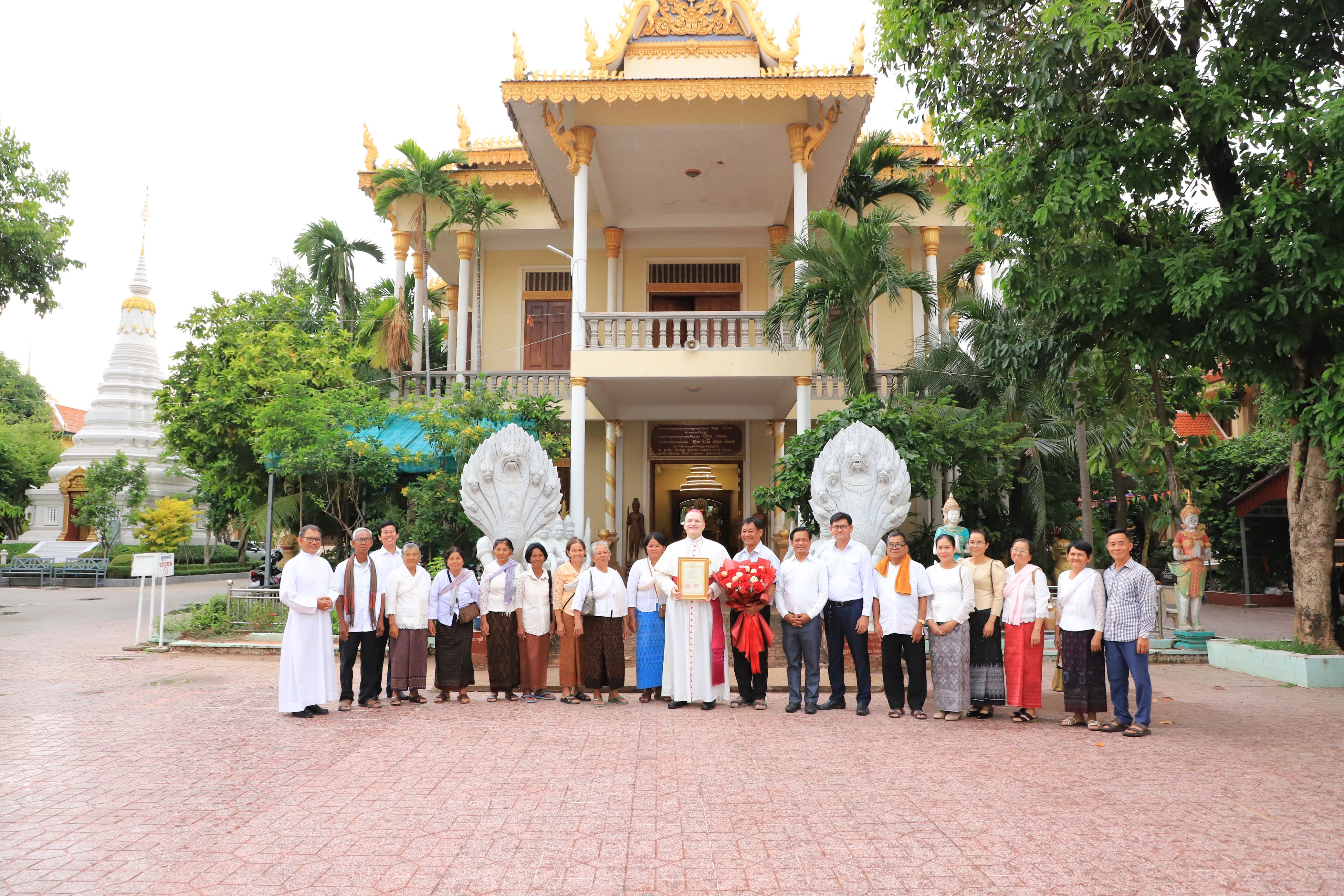 Bishop Olivier Schmitthaeusler poses with community members outside Wat Botum Vatey in Phnom Penh on June 13, 2026, after receiving a high honorary title from Cambodiaʼs Buddhist leadership in recognition of his work promoting Buddhist-Christian cooperation. | Credit: Ly Sovanna/Catholic National Office for Social Communications in Cambodia